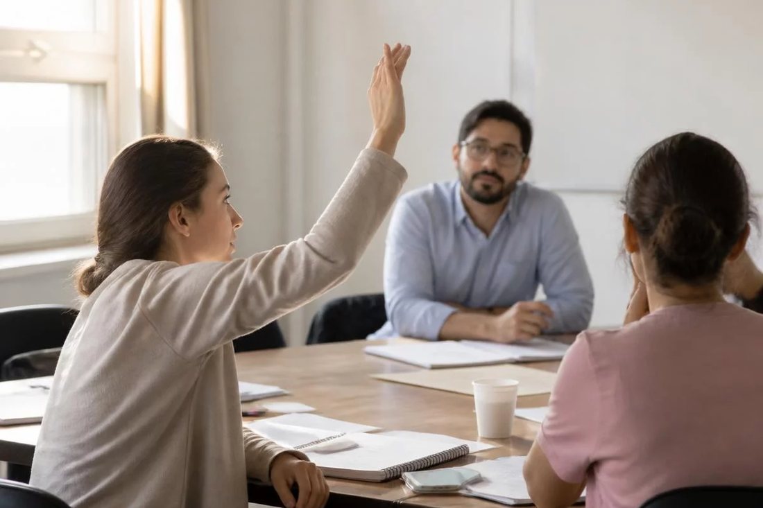 Facilitador em pé apontando para um argumento escrito no quadro durante a sessão